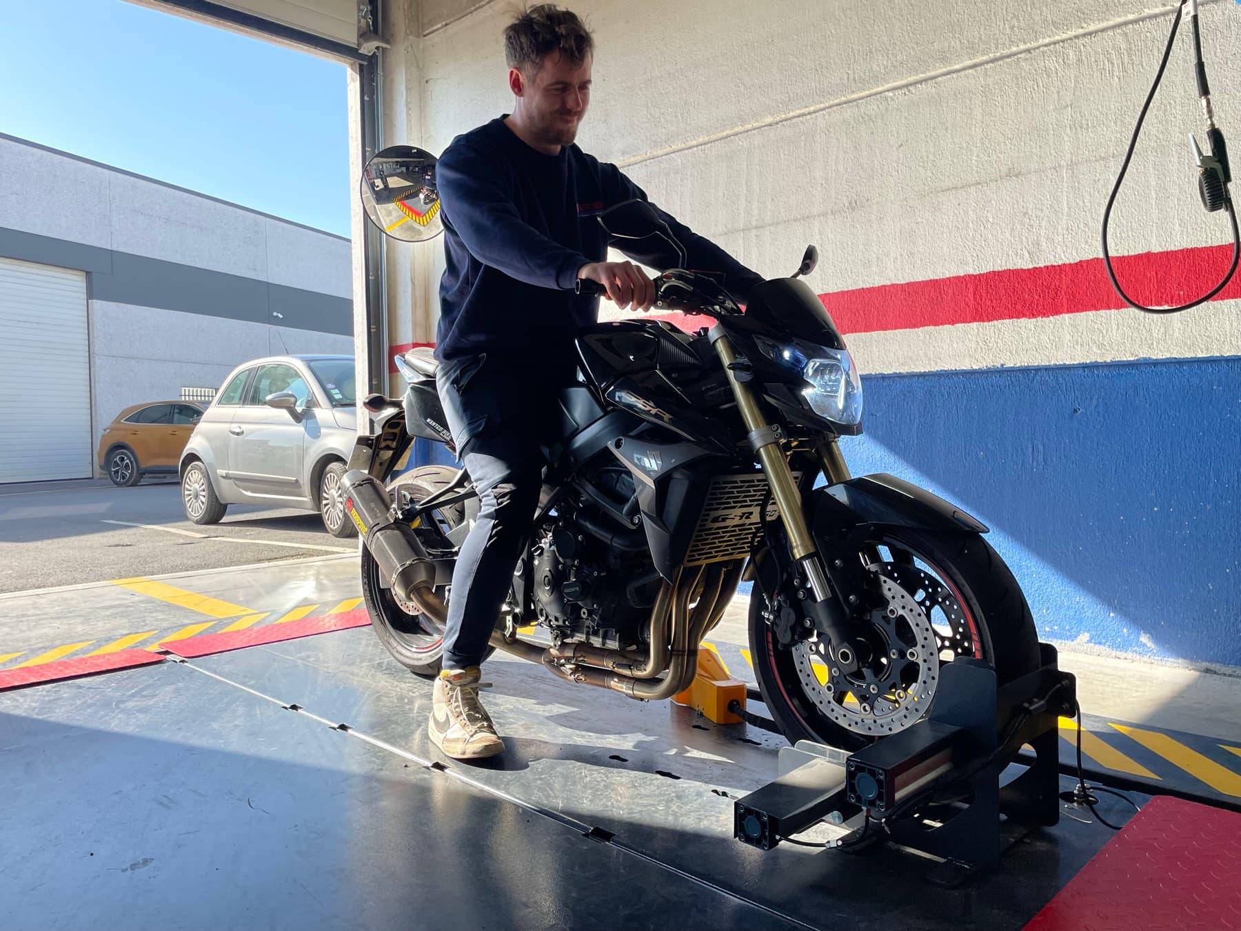 Un contrôleur technique installe une moto sur la piste de contrôle du centre Motovision Seclin