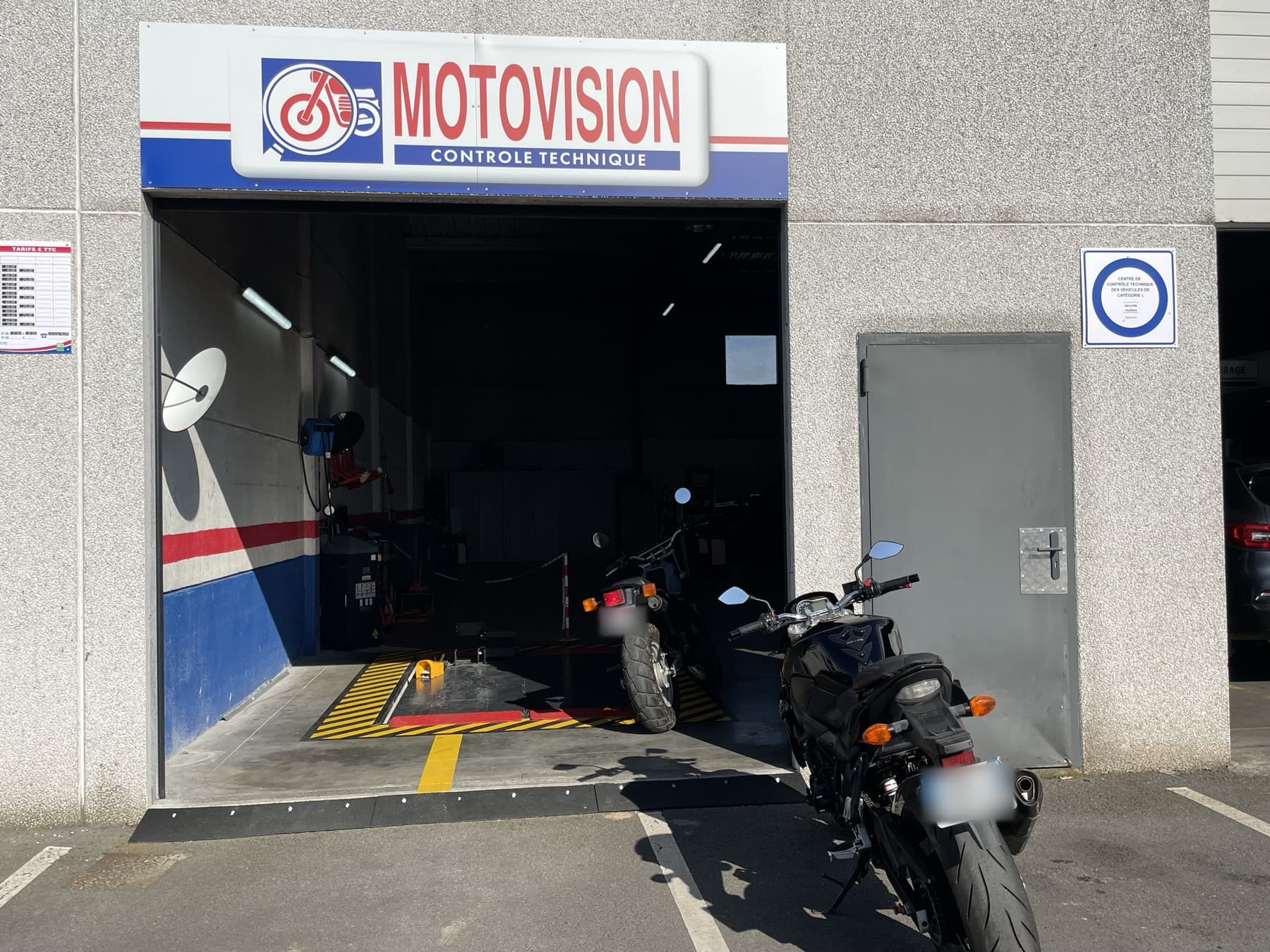 Façade du centre Motovision Seclin, enseigne au-dessus de la baie de contrôle, motos stationnées devant